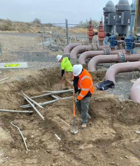 A worker on site digging in the ground.